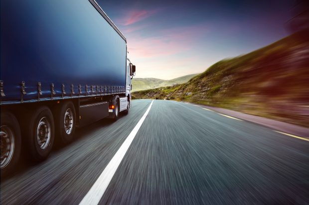 Lorry driving on country road.